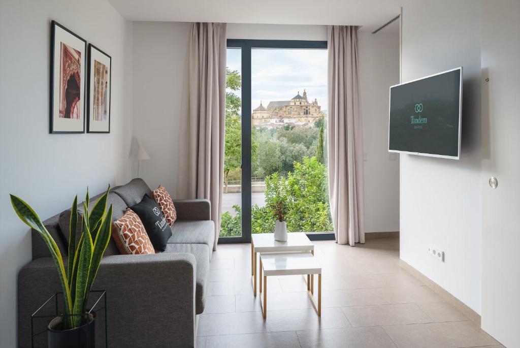 sala de estar con sofá y ventana grande en Tandem Torre de la Calahorra en Córdoba