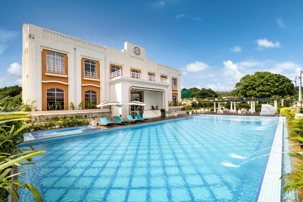 una piscina frente a un edificio en Imperial Goa en Old Goa