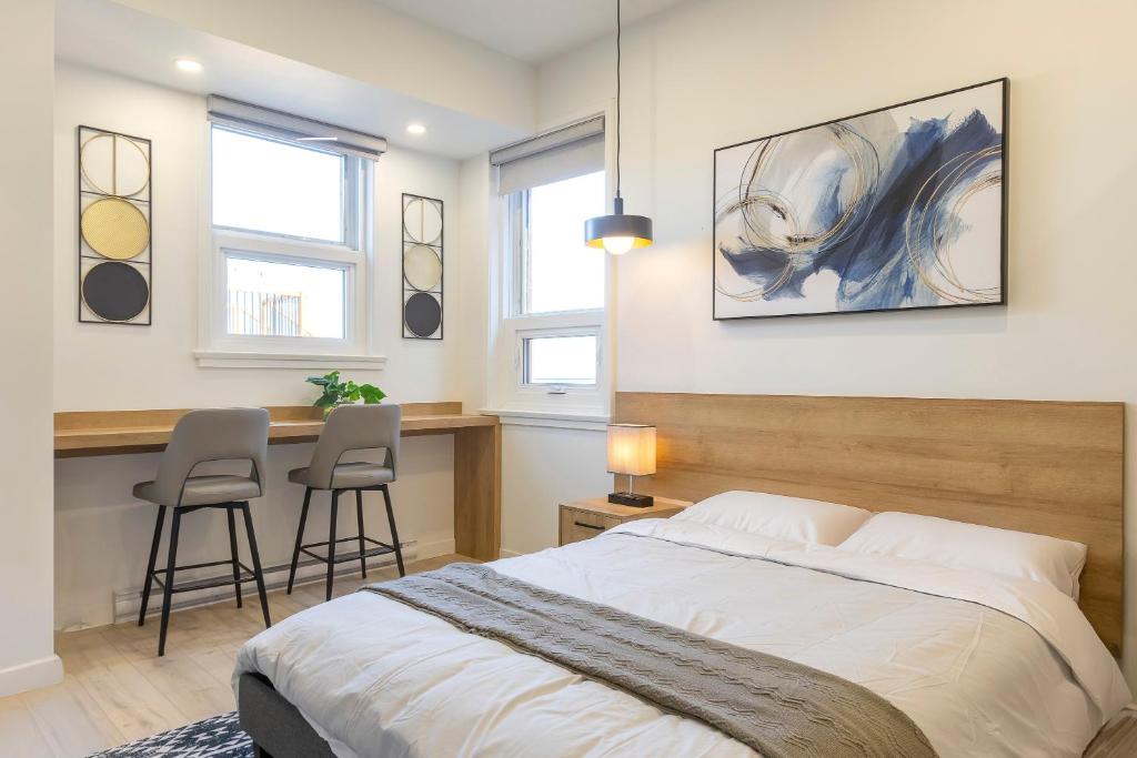 a bedroom with a bed and a desk with two chairs at Lofts Orizon in Rimouski