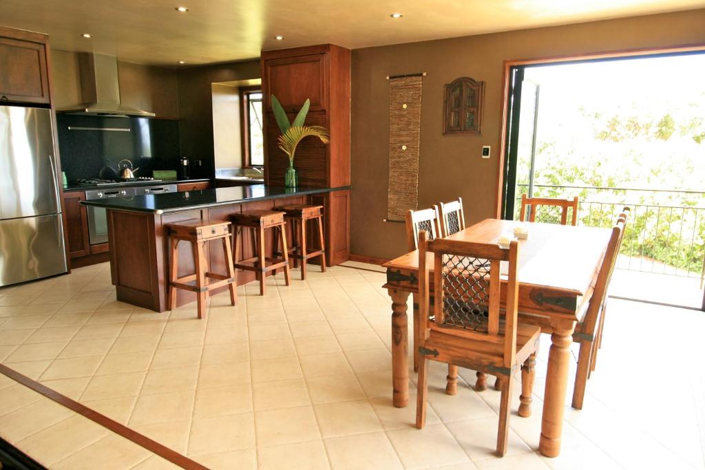 cocina con mesa, sillas y barra en Auwas Island Holiday Home en Burnt Pine