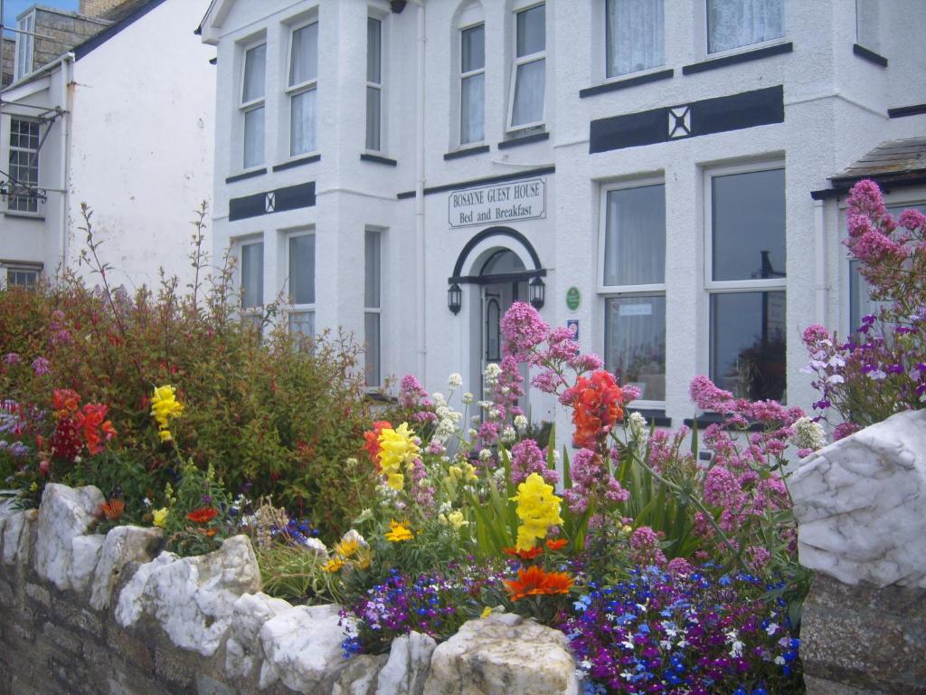 un jardín de flores frente a un edificio en Bosayne Guest House, en Tintagel