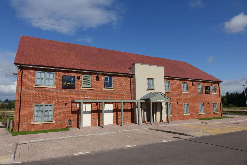 un gran edificio de ladrillo con techo rojo en Fallow Field, Telford by Marston's Inns, en Telford