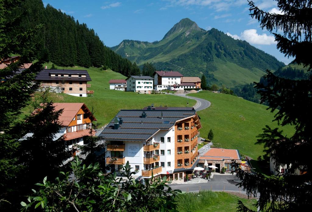 a group of buildings on a hill with a mountain at Hotel Walliserstube in Damuls