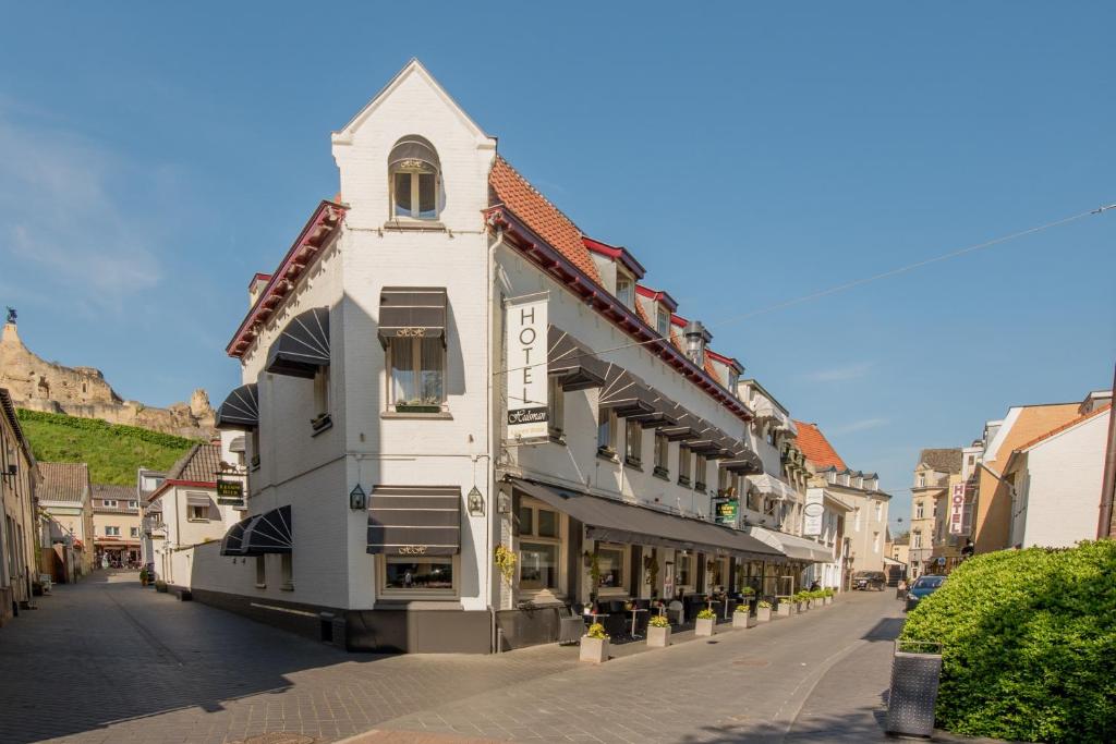 biały budynek z wieżą zegarową na ulicy w obiekcie Hotel Hulsman w mieście Valkenburg