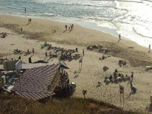 eine Gruppe von Menschen an einem Strand in der Nähe des Wassers in der Unterkunft Ocean View Luxury apartment in Netanya