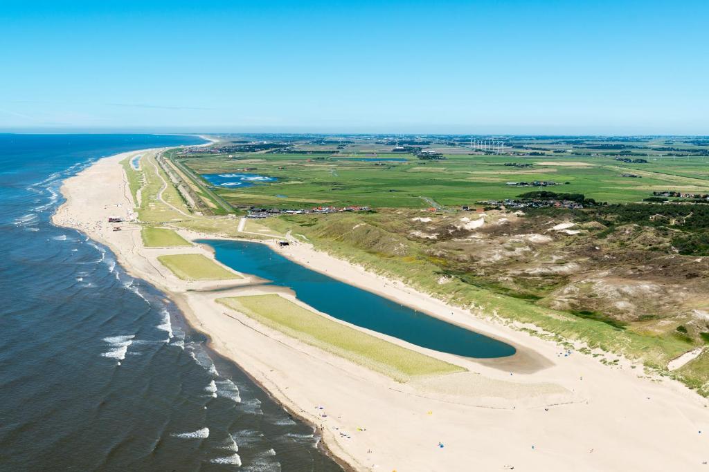 una vista aerea sulla spiaggia e sull'oceano di Strandhotel Camperduin a Schoorl