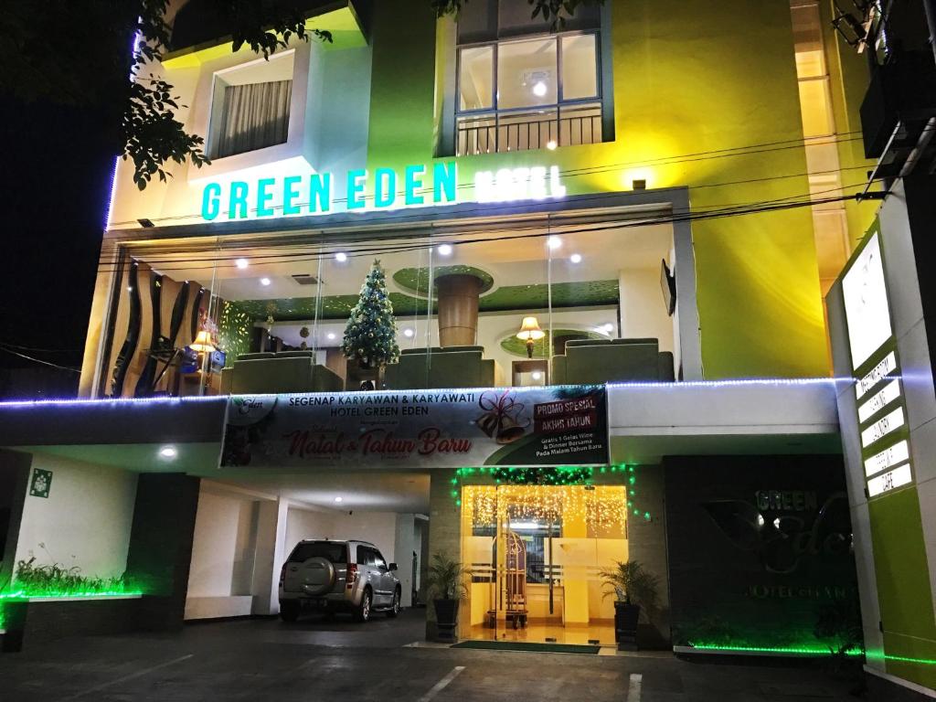 um hotel Greenbell à noite com um carro estacionado em frente em Green Eden Hotel em Manado