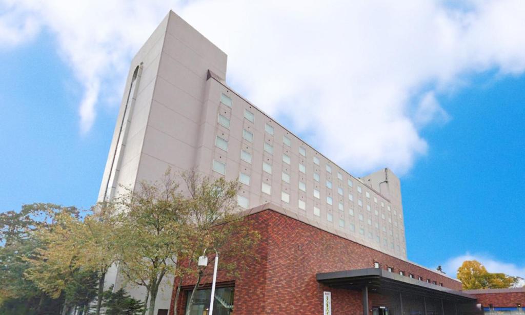 ein hohes weißes Gebäude mit rotem Backstein in der Unterkunft Hotel Grand Terrace Chitose in Chitose