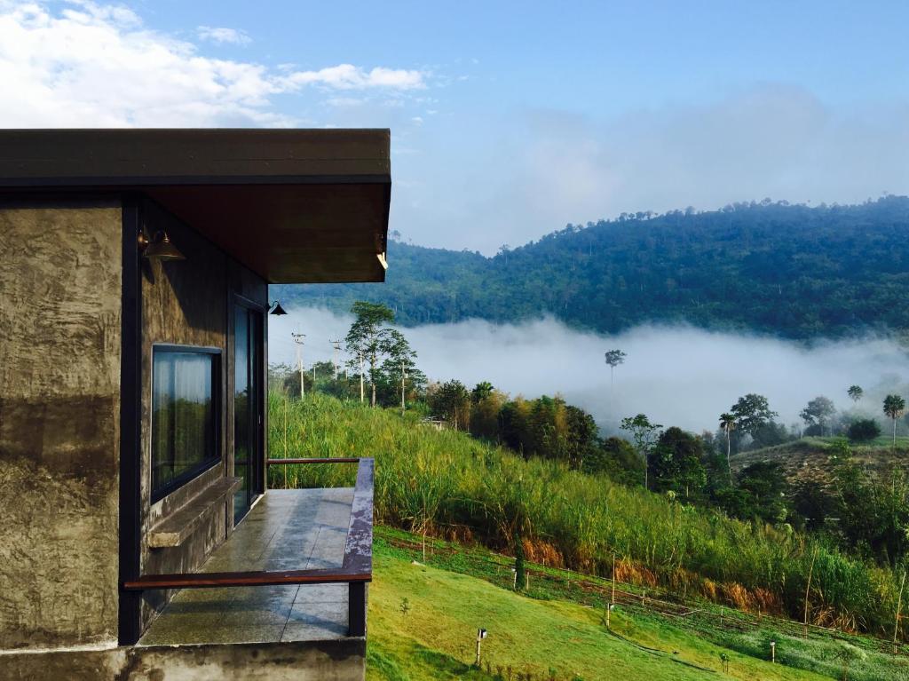 uma casa com uma varanda com vista para uma montanha em Bann Ton Kho em Khao Kho