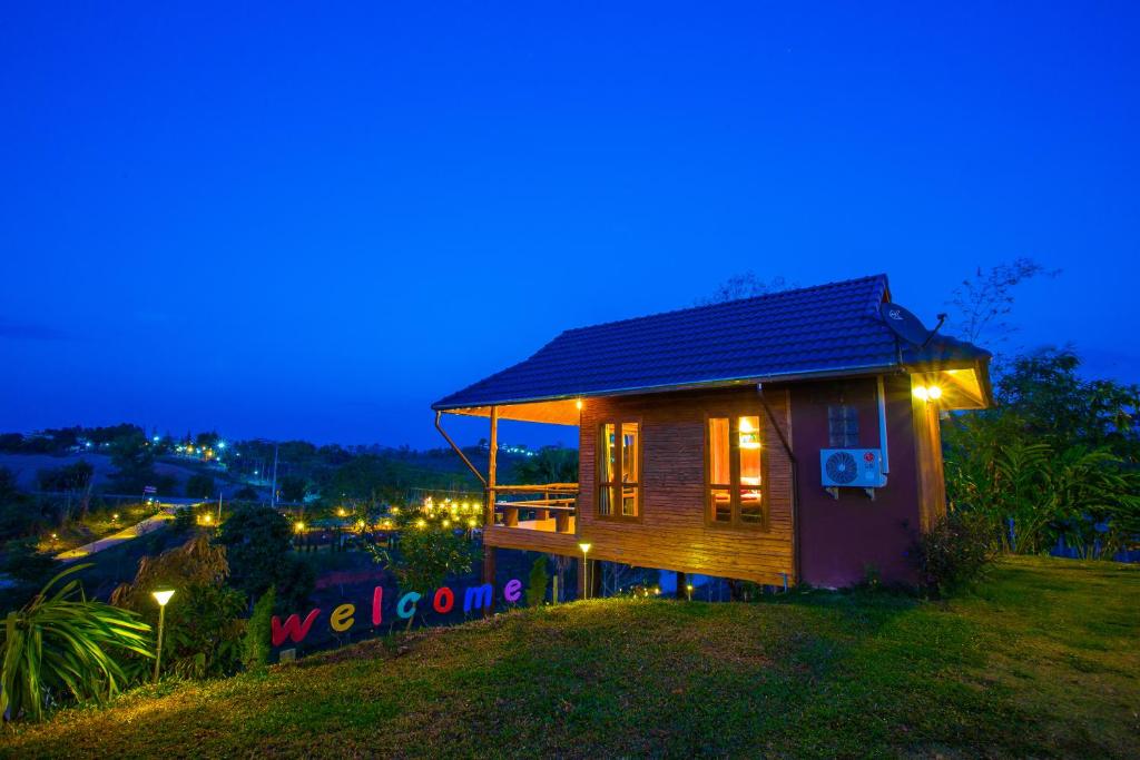 uma pequena casa de madeira com luzes à noite em Tarahill Khao Kho em Khao Kho