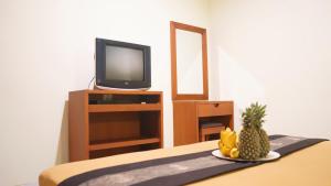 a room with a television and a plate of fruit at Pondok Mirah in Kuta