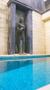 a statue of a woman standing next to a swimming pool at Pondok Mirah in Kuta