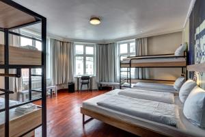 Zimmer mit 2 Etagenbetten und einem Schreibtisch in der Unterkunft Urban House Copenhagen by MEININGER in Kopenhagen