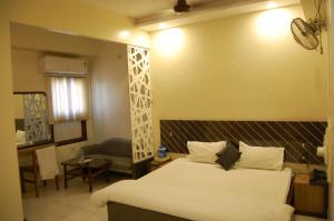 um quarto de hotel com uma cama, uma mesa e uma cadeira em Hotel New Sunder em Indore