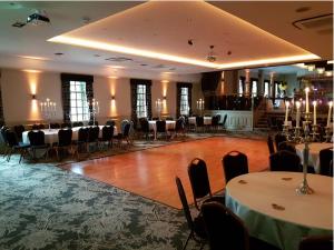 un salón de banquetes con mesas y sillas en una habitación en The Parkville Hotel, en Hamilton