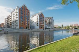 einen Fluss in einer Stadt mit hohen Gebäuden und Apartments in der Unterkunft GRANO APARTMENTS Gdańsk Nowa Motława SPA & Wellness in Danzig