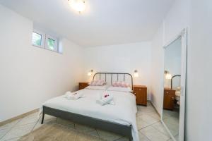 1 dormitorio con 1 cama con sábanas blancas y espejo en Apartman Tonko en Novigrad Dalmatia