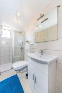 y baño blanco con lavabo y ducha. en Apartman Tonko en Novigrad Dalmatia