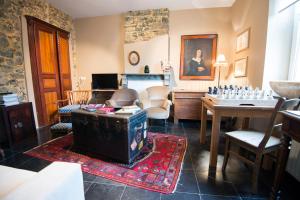 Cette chambre comprend un salon avec une table. dans l'établissement B&B Le Vieux Marronnier, à Foy-Notre-Dame