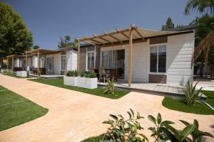 Ein Haus mit einer Terrasse und einem Haus in der Unterkunft Camping Los Llanos in Denia