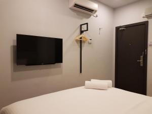 - une chambre avec un lit et une télévision murale à écran plat dans l'établissement The Leverage Lite (Kuantan), à Kuantan