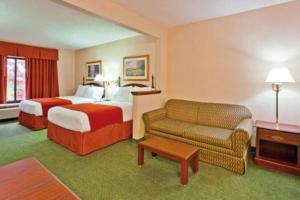 um quarto de hotel com duas camas e um sofá em Auburn Place Hotel & Suites Paducah em Paducah