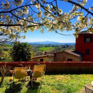 two chairs and a table in a yard with flowers at Hotel Santa Caterina in Siena