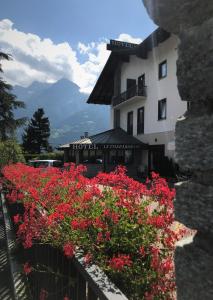 un hotel con flores rojas frente a un edificio en Le Charaban en Aosta