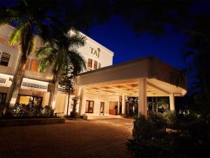 un edificio con una palmera delante de él en Taj Connemara, Chennai, en Chennai