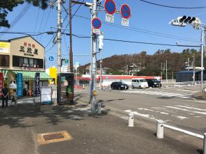 um cruzamento com uma rua com uma paragem de autocarro em Dormitory Sandanya Guesthouse em Shirahama