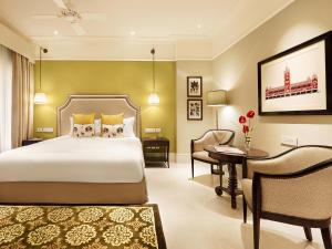 1 dormitorio con cama, escritorio y silla en Taj Connemara, Chennai, en Chennai