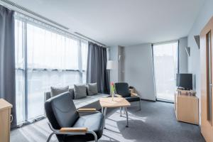 Cette chambre d'hôtel dispose de chaises, d'un canapé et d'une télévision. dans l'établissement Weiser Hotel, à Wrocław