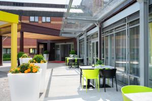 een patio met tafels en stoelen in een gebouw bij Thon Hotel Bergen Airport in Bergen