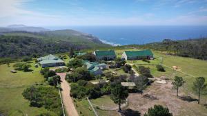 una vista aérea de una casa en una colina junto al océano en TNiqua Stable Inn en Plettenberg Bay