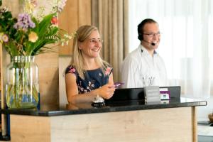 een man en een vrouw die achter een toonbank staan bij Sapia Hotel Rheinsberg in Bad Säckingen