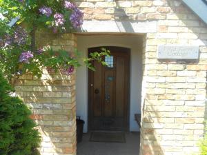 uma entrada para uma casa de tijolos com uma porta de madeira em Villa Farm Cottage em Thornton Curtis