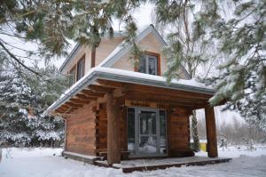 ビャウォヴィエジャにあるŚwironekの屋根に雪が積もった丸太キャビン