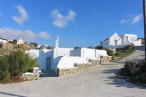 een rij witte gebouwen op een onverharde weg bij Crystal View Mykonos in Mykonos-stad