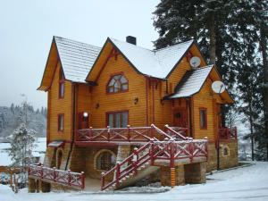 una grande casa in legno con neve sul tetto di Норіс a Myhove