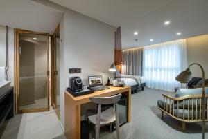 een hotelkamer met een bureau en een slaapkamer bij 9Hotel Paquis in Genève