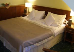 a hotel room with a large bed with white pillows at Hotel Selsky Dvur - Bohemian Village Courtyard in Prague