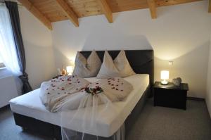 1 dormitorio con 1 cama grande con sábanas y almohadas blancas en Ferienhaus Manuela en Velden am Wörthersee