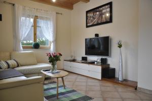 sala de estar con sofá y TV en Ferienhaus Manuela en Velden am Wörthersee