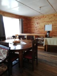 comedor de madera con mesa y sillas en Puesto Cánogas Hostal en Villa O'Higgins