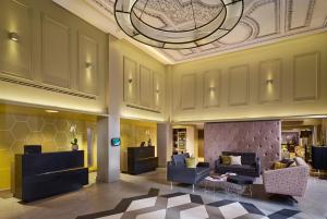 una hall con divani, sedie e soffitto di Citadines Trafalgar Square a Londra