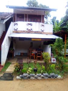 uma casa com um alpendre com uma mesa em Jayanika home stay em Tangalle