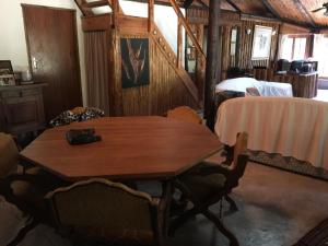 uma mesa de madeira e cadeiras num quarto com uma cama em Toad Tree Cabins em Sodwana Bay