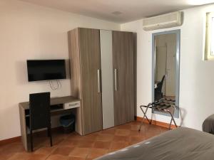 una camera da letto con un grande mobile in legno con televisore di Hotel Nettuno a Napoli