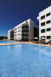 una gran piscina frente a dos edificios en Leo Deluxe Punta Umbría, en Punta Umbría