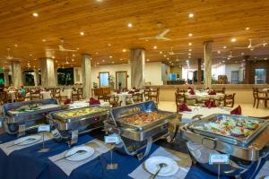 una línea de buffet con varias bandejas de comida en un restaurante en Hotel Sudu Araliya en Polonnaruwa